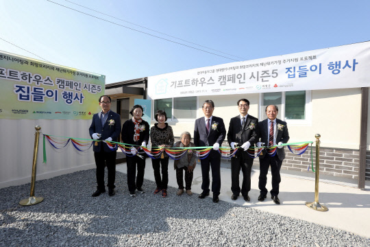 지난 5일 경남 의령군 유곡면에서 진행된 '기프트하우스 캠페인 시즌5' 집들이 행사에 참석한 수혜 주민(사진 가운데), 이선두 의령군 군수(사진 오른쪽에서 세 번째), 손태영 의령군 의회 의장(사진 오른족 맨끝), 이상훈 현대엔지니어링 CSR팀장(사진 오른쪽에서 두 번째), 김정희 희망브리지 사무총장(사진 왼쪽에서 두 번쨰) 등 관계자들이 리본 컷팅을 진행하고 있다. <현대엔지니어링 제공>